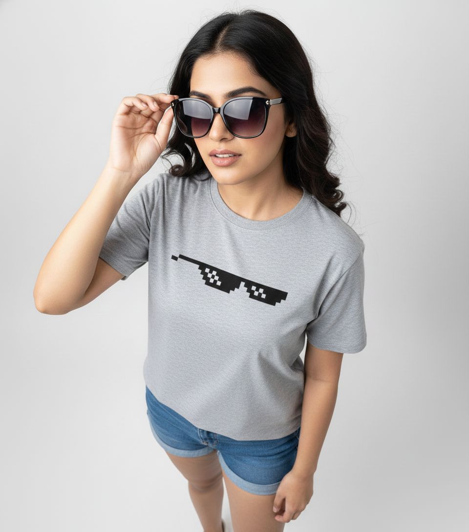 Woman wearing a gray t-shirt with a black graphic design on a plain background