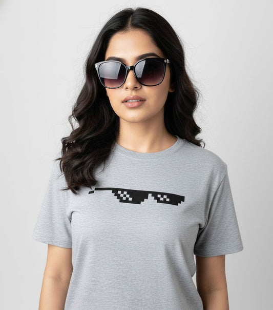 Woman wearing a gray t-shirt with pixelated sunglasses design on a plain background